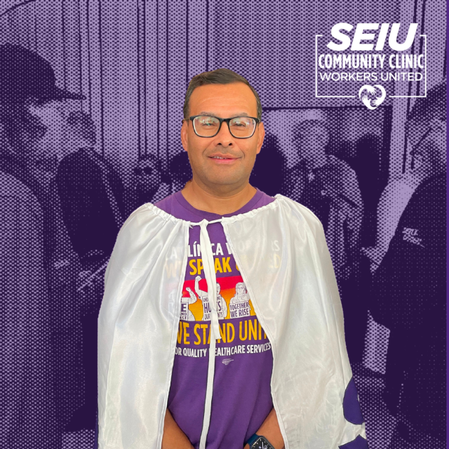 La Clinica Worker, Angel Valdez wearing the SB 525 action "Clinic Workers are Superheroes" cape.