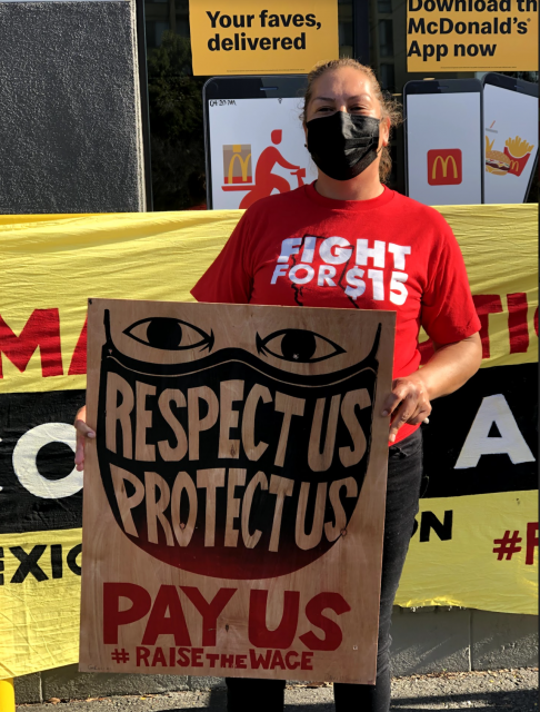 McDonald's worker Maria Ruiz stands in front of a McDonald's location in West Oakland, CA at the Fight for 15 car caravan on Friday, January 15, 2021.