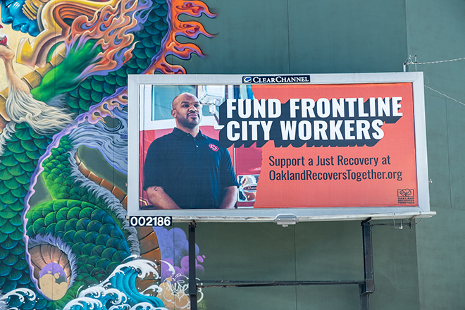 A billboard featuring an IAFF 55 member, reading "Fund Frontline City Workers"